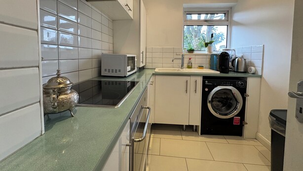 A compact kitchen with a microwave, sink, and dishwasher.