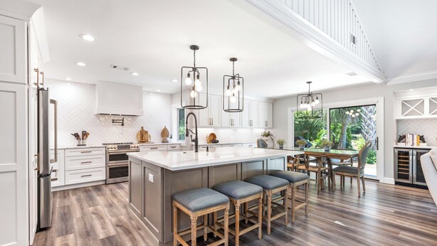 A modern kitchen with a large island, bar stools, and pendant lighting. - 60 Lawton Rd: Sea Pines (Hilton Head)