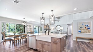 A spacious kitchen with a large island, wooden cabinetry, and pendant lighting. - 60 Lawton Rd: Sea Pines (Hilton Head)