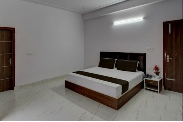 Une chambre moderne avec un grand lit, une table de chevet et une porte en bois.