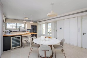 A modern kitchen with a central island, bar stools, and pendant lighting. - #Breathtaking 4BR/3BA Duplex Seafront (Tel Aviv-Yafo)