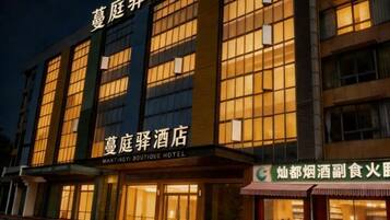 A hotel with a sign reading 'MANTINGY BOUTIQUE HOTEL' and a smaller sign for a restaurant.