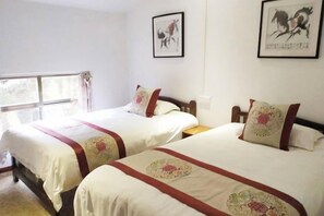 A hotel room with two beds, each with a red and white bedspread, a window with curtains, and two framed pictures on the wall. - Huangyao Guyaju Farm Inn (Zhaoping)