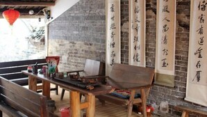 Un interior tradicional con muebles de madera, pared de ladrillo y caligrafía china.