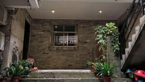 Un estrecho pasillo de paredes de piedra con una pequeña ventana y escalones que conducen a una plataforma.