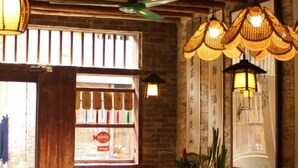 Un interior rústico con paredes de ladrillo visto, iluminación de estilo farol y un escaparate de madera.