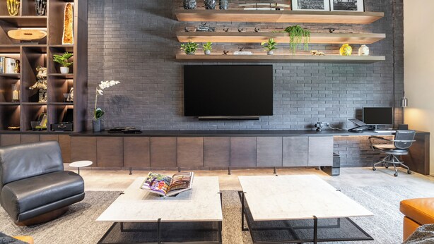 A modern living room with a flat-screen TV, a sofa, two coffee tables, and a bookshelf with decorative items. - Wynwood Condo, Walk to Restaurants & Nightclubs! (Miami)