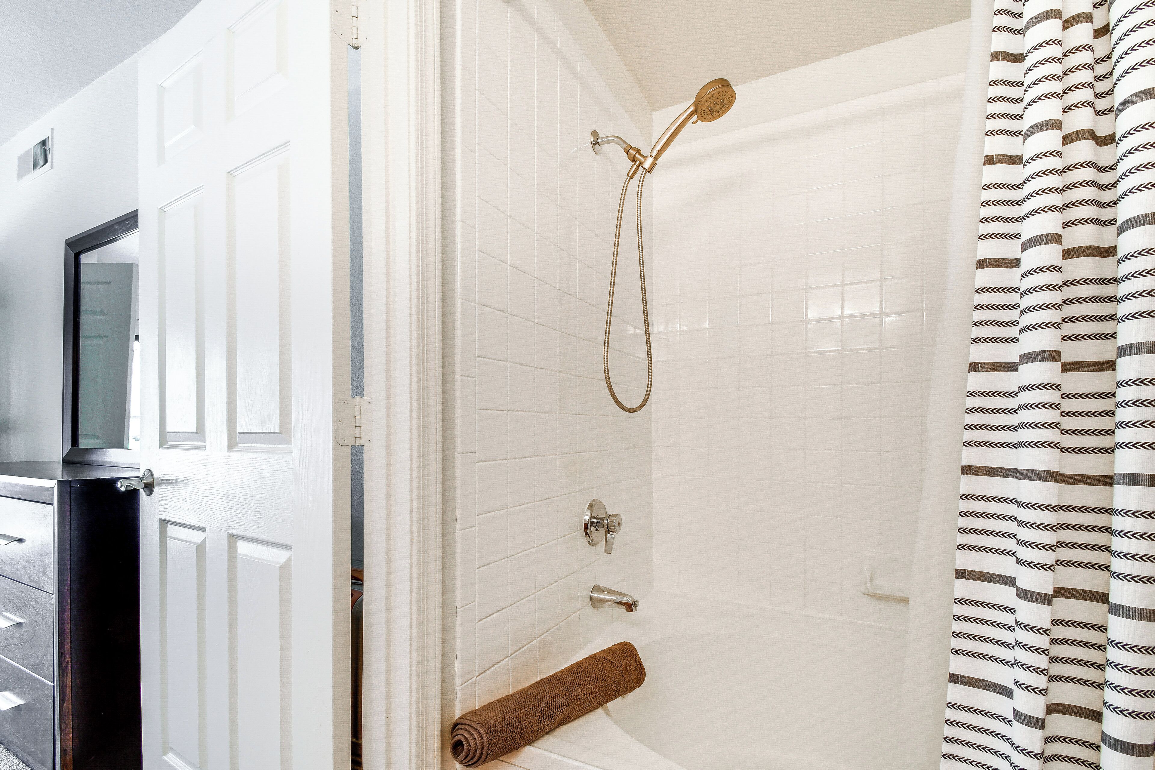 A bathroom with a shower, a toilet, and a bathtub.