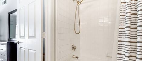 A bathroom with a shower, a toilet, and a bathtub.