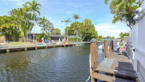 A wooden dock extending over a calm waterway, surrounded by lush greenery and palm trees. - Pompano Beach Home w/ Pool & Dock ~ 4 Mi to Pier! (Pompano Beach)