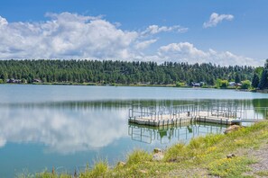 A calm lake with a dock and a forested shoreline. - Steps to Lake Pagosa! Remodeled Home w/ Sleds (Pagosa Springs)