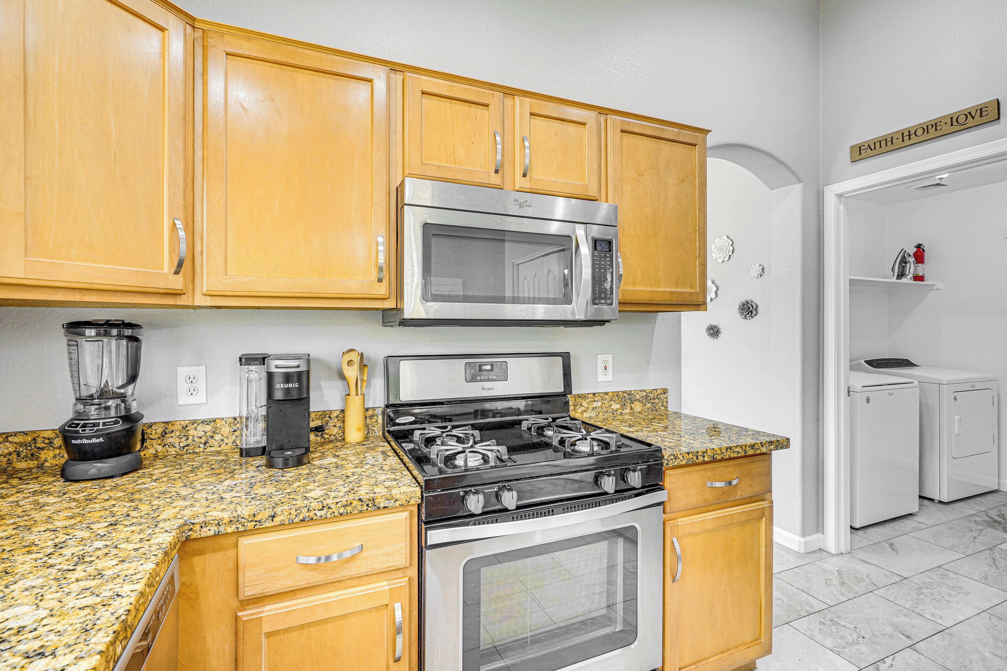 A kitchen with wooden cabinets, a stainless steel microwave, a gas stove, and a built-in oven.