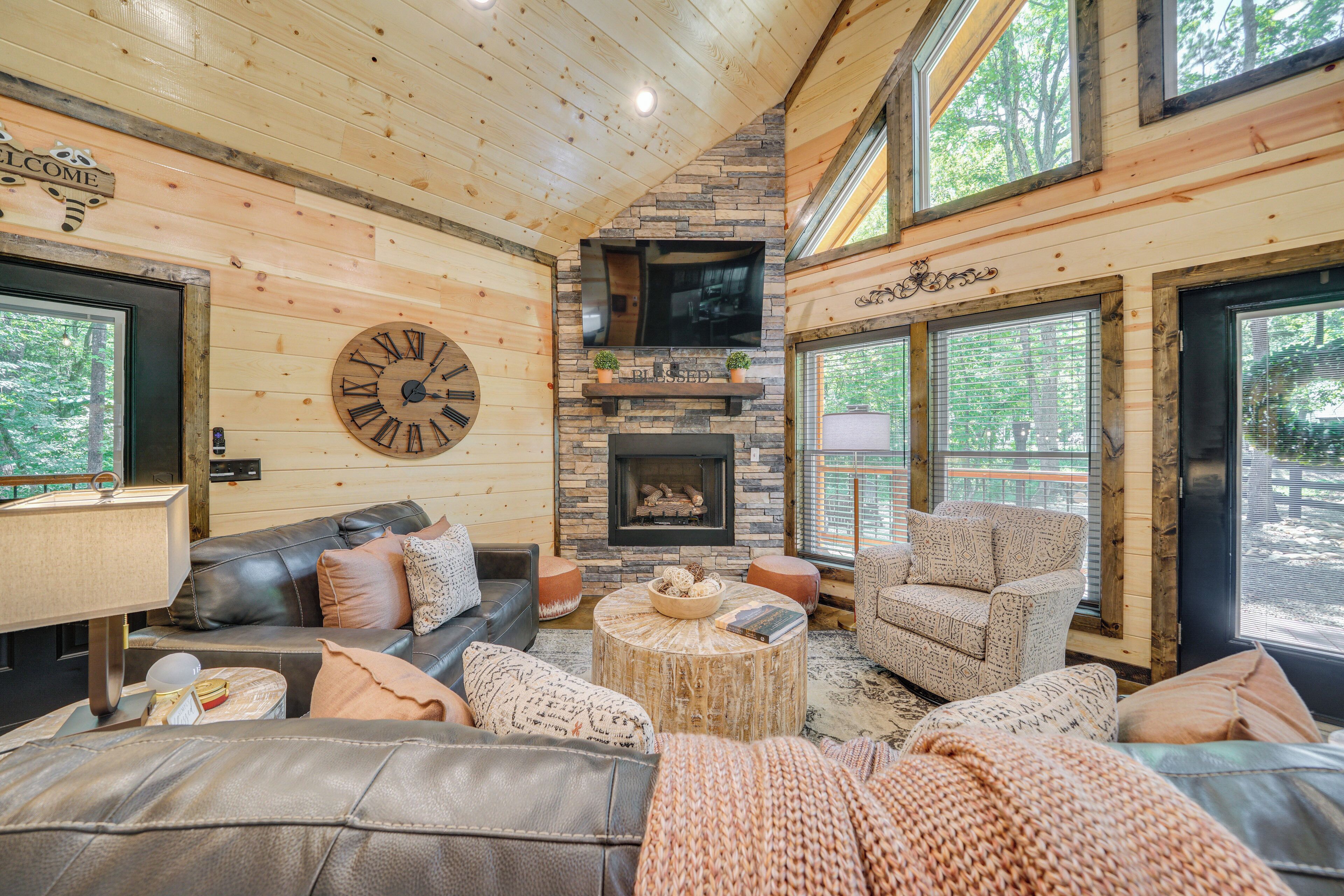 Ein gemütliches Blockhaus-Interieur mit Kamin, Ledersofas und einer großen Wanduhr.