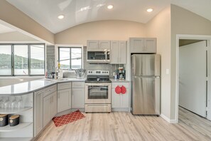 A modern kitchen with a large island, stainless steel appliances, and a view of a lake. - Walk to Harveys Lake! Modern Apt w/ Water Views (Harveys Lake)