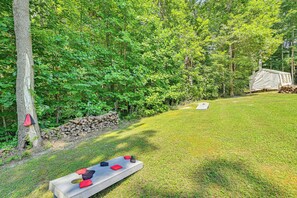 A grassy outdoor area with a bench and a tent. - 5 Mi to Cave Run Lake: Wellington Cabin w/ Deck! (Wellington)