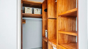 A wooden closet with multiple shelves and drawers, some containing decorative boxes. - Private Pool & Patio Haven, 3BR House near Beach (Noord)