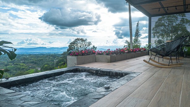 A hot tub with a view of mountains, a wooden deck, and a chair. - Casita 2 Beautiful Cabin - Stunning View (Filandia)
