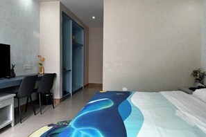 A hotel room with a bed, a desk, two chairs, a television, and a wardrobe. - Wangfuzhou Holiday Villa Hotel (Taishan)