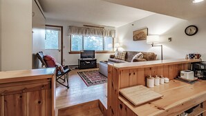 Una sala de estar acogedora con un sofá, televisor y muebles de madera.