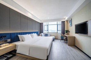 A modern hotel room with a large bed, a desk, a TV, and a window with curtains. - Bai Yas Hotel (Zunyi Haier Avenue &Wuyue PIaza Branch) (Zunyi)
