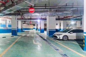 An indoor parking garage with a no entry sign, concrete pillars, and a white car parked. - Bai Yas Hotel (Zunyi Haier Avenue &Wuyue PIaza Branch) (Zunyi)