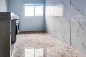 A narrow hallway with a washing machine, a window, and marble walls. - Bai Yas Hotel (Zunyi Haier Avenue &Wuyue PIaza Branch) (Zunyi)