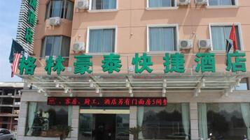 A hotel with a signboard displaying its name and services.