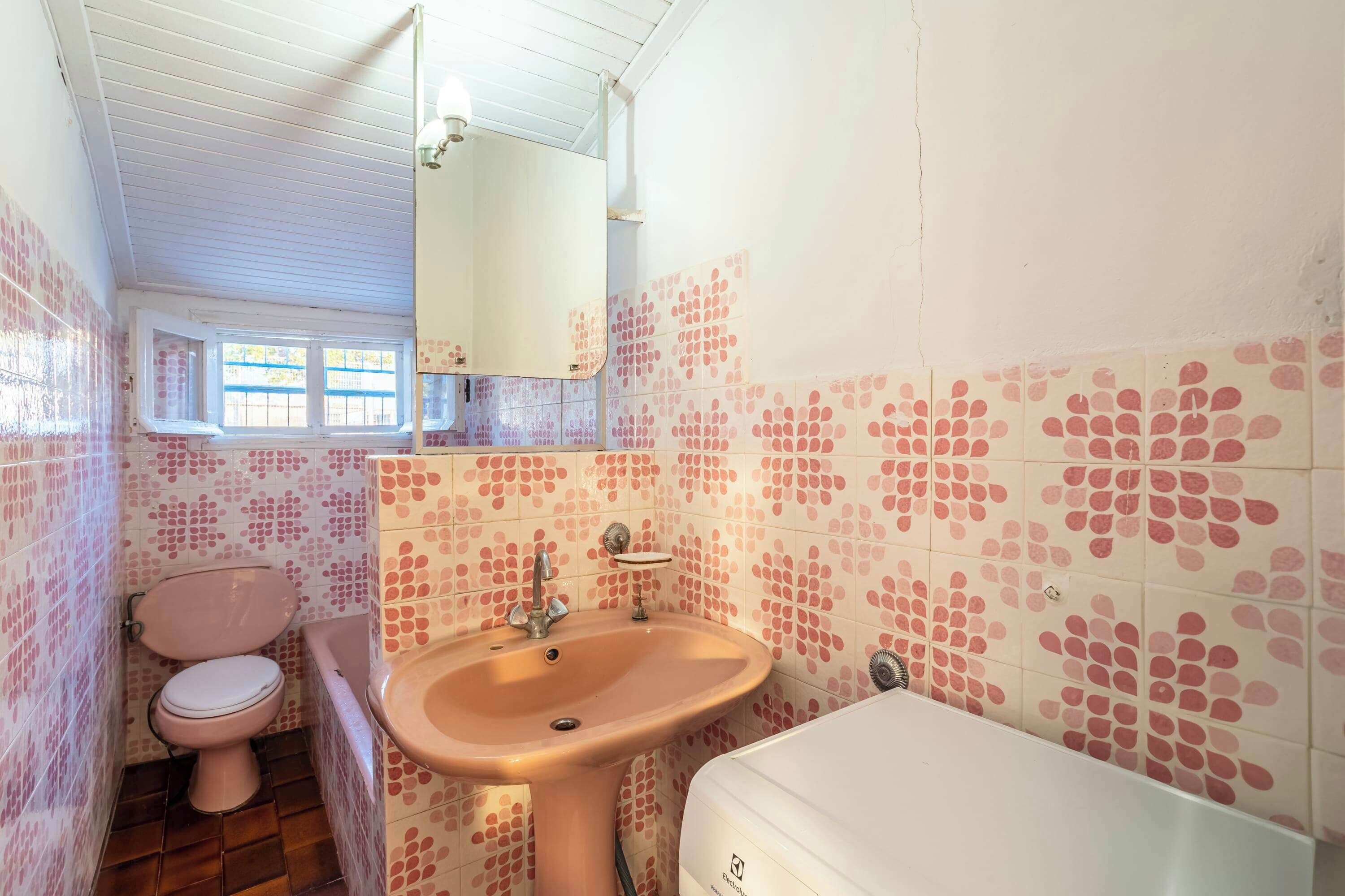 A bathroom with a pink toilet, a sink, and a bathtub.