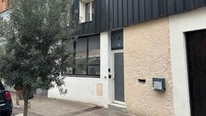 A modern building with a mix of wooden and metal facades, a small tree in the foreground, and a paved walkway. - Loft Proche Centre Paris y Loger ou Professionnel (Suresnes)