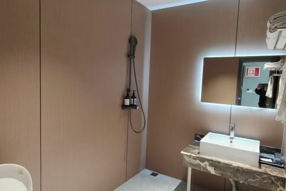 A modern bathroom with a built-in sink, a mirror, and a shower.