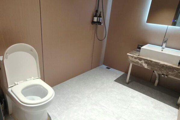 A bathroom with a toilet, a sink, and a shower.