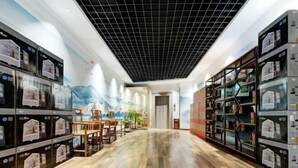A spacious room with a wooden floor, a large mural on the wall, and shelves with items on both sides. - Paoshe Audio Hotel (Dingzikou shop, Zunyi clubhouse) (Zunyi)