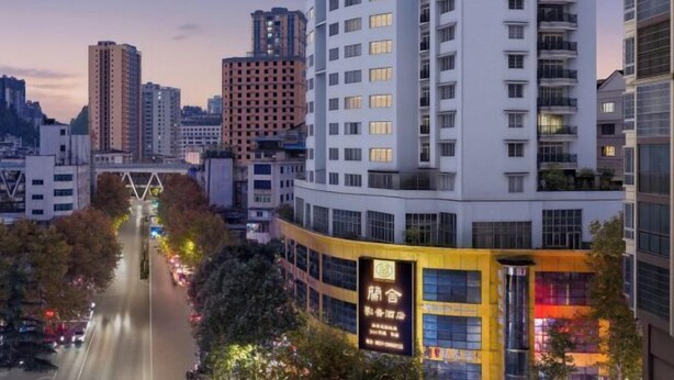 A multi-story hotel with a modern design, featuring a prominent entrance and a visible signboard. - Paoshe Audio Hotel (Dingzikou shop, Zunyi clubhouse) (Zunyi)