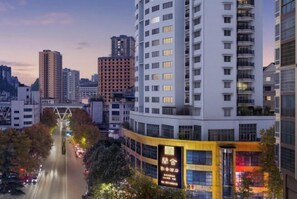 A multi-story hotel with a modern design, featuring a prominent entrance and a visible signboard.