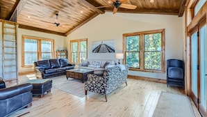 A spacious living room with a high ceiling, large windows, and a ceiling fan. - Rocky Mountain Retreat 4 Bedroom Home by RedAwning (Black Hawk)