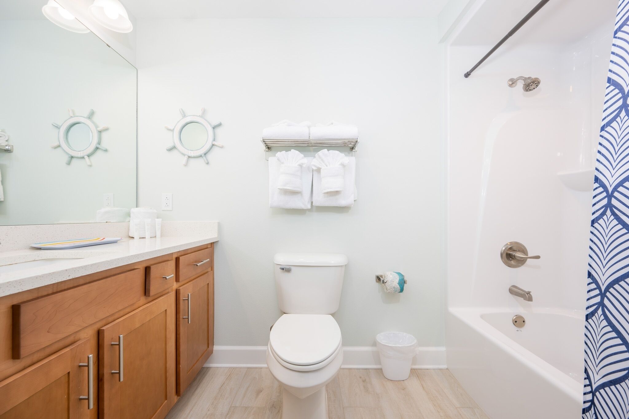 A bathroom with a toilet, sink, vanity, towel rack, and bathtub.