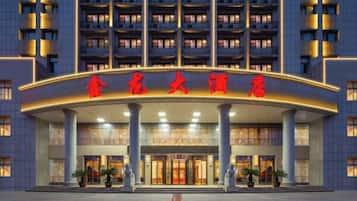 A hotel entrance with a large sign and multiple floors.