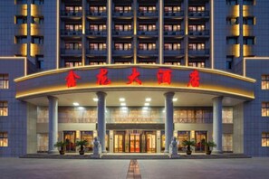 A hotel entrance with a large sign and multiple floors. - Xinlong Hotel (Wuhan)