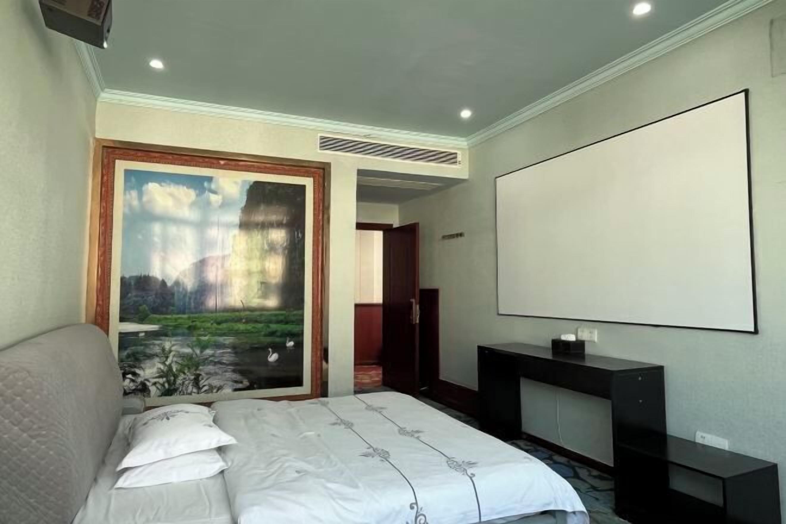 Une chambre à coucher avec un lit, un bureau et une grande fenêtre donnant sur un paysage.