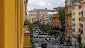 A busy urban street with historic buildings, a tram, and parked cars. - Grazioli Vatican Home (Roma)