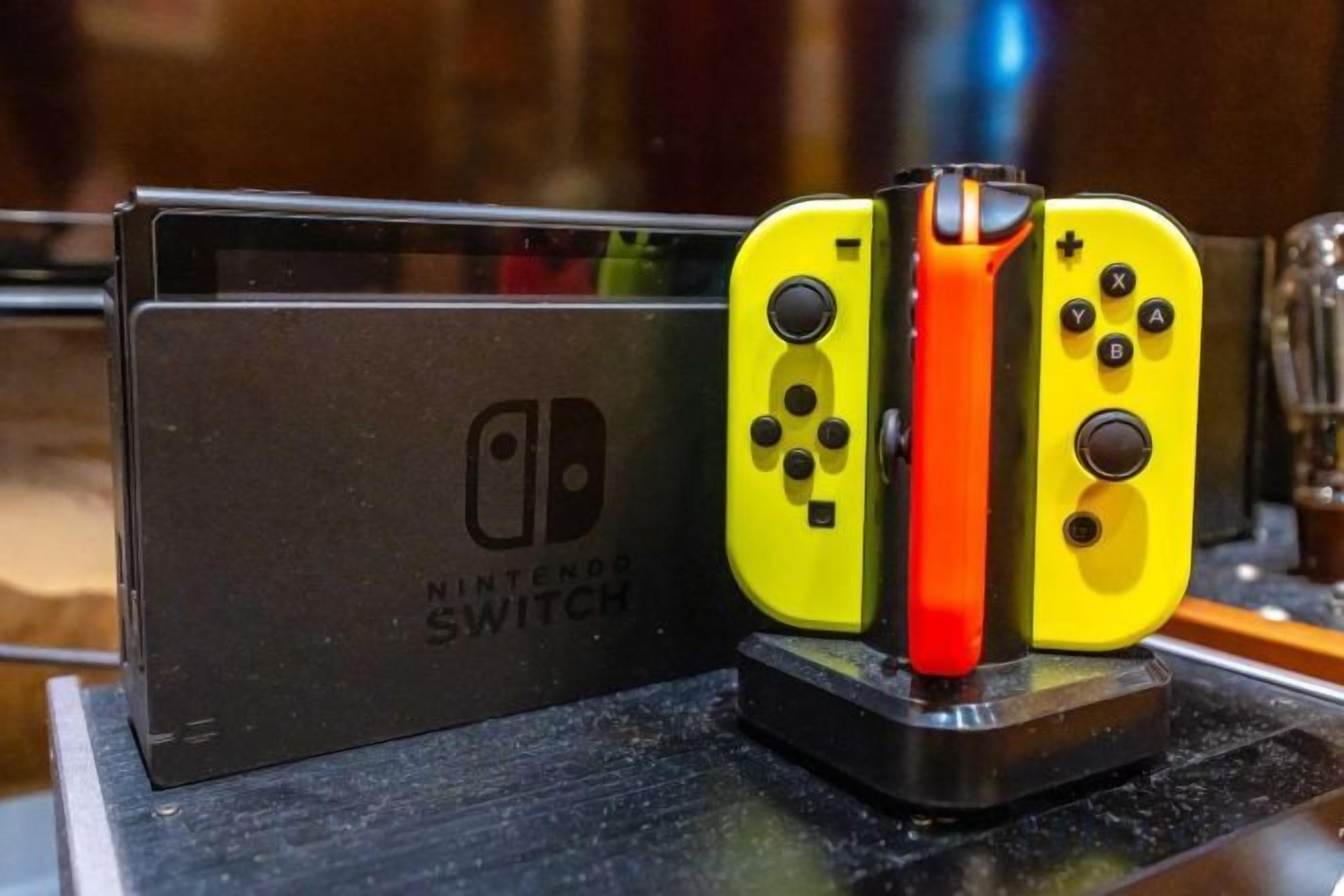A Nintendo Switch console with two controllers on a stand.
