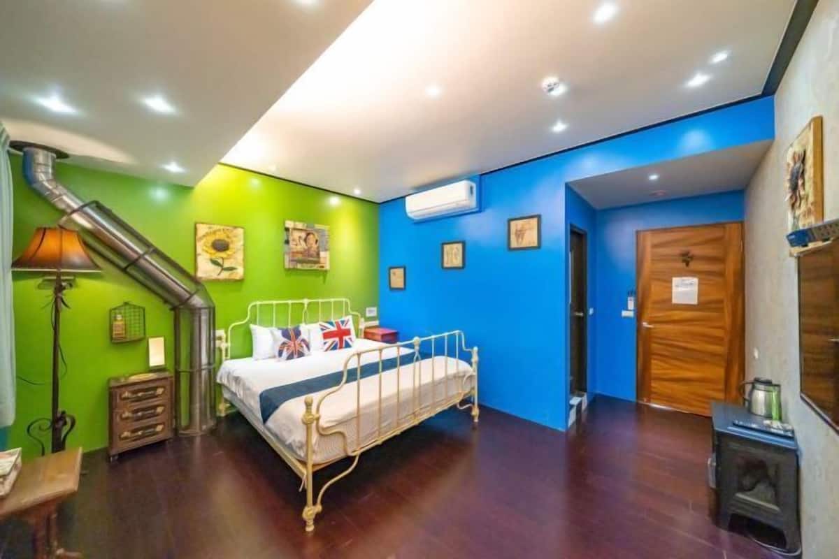 Ein Schlafzimmer mit einem Bett, einem Heizgerät, einer Lampe und einer Tür.