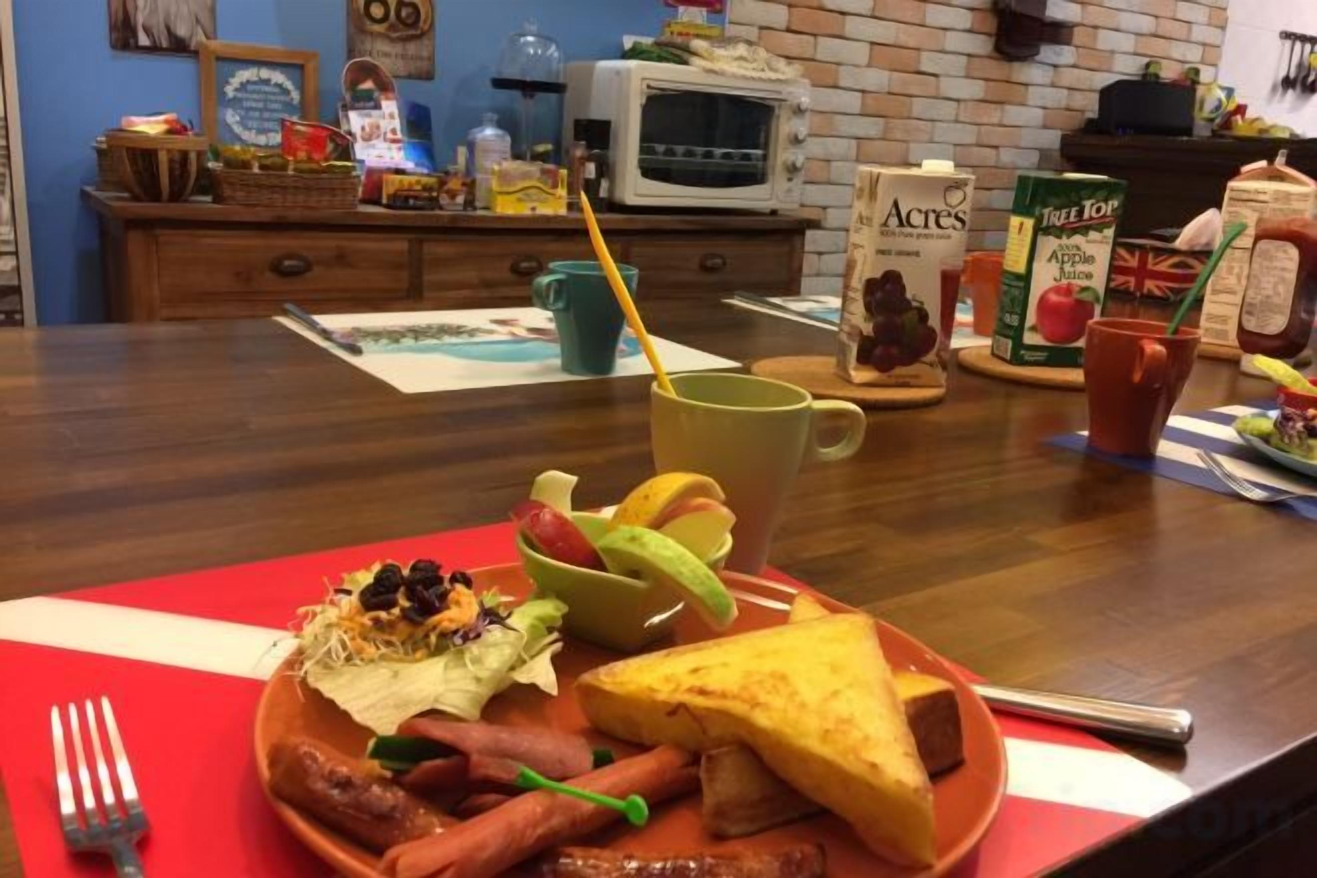 A breakfast plate with sausages, a grilled cheese sandwich, and a cup of coffee on a red placemat.