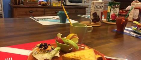 A breakfast plate with sausages, a grilled cheese sandwich, and a cup of coffee on a red placemat.