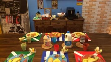 A dining table with plates of food, cups, and a milk jug.
