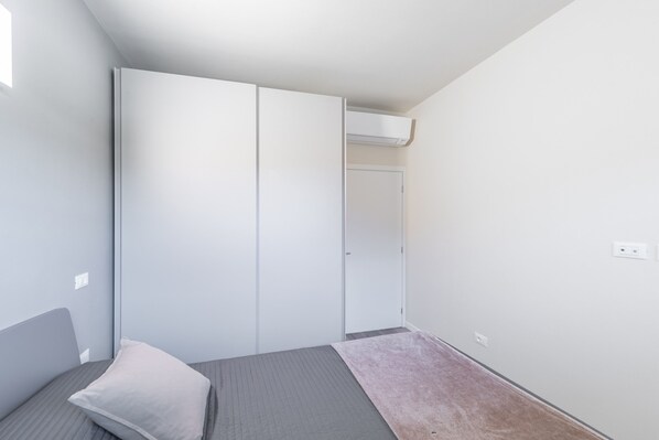 Ein Schlafzimmer mit einem Bett, einem Kleiderschrank und einer Tür.
