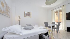 Una moderna camera d'albergo con un letto, una scrivania e un'area ristorazione.
