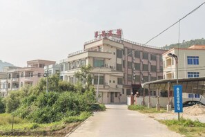 A multi-story building with a flat roof and a signboard on the top.