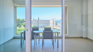 A balcony with a dining table and chairs, a view of buildings and greenery, and a clear sky. - Tropic Night Apartment by Litto (Split)