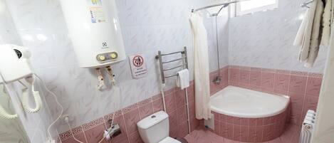 Un baño con inodoro, bañera y ducha.